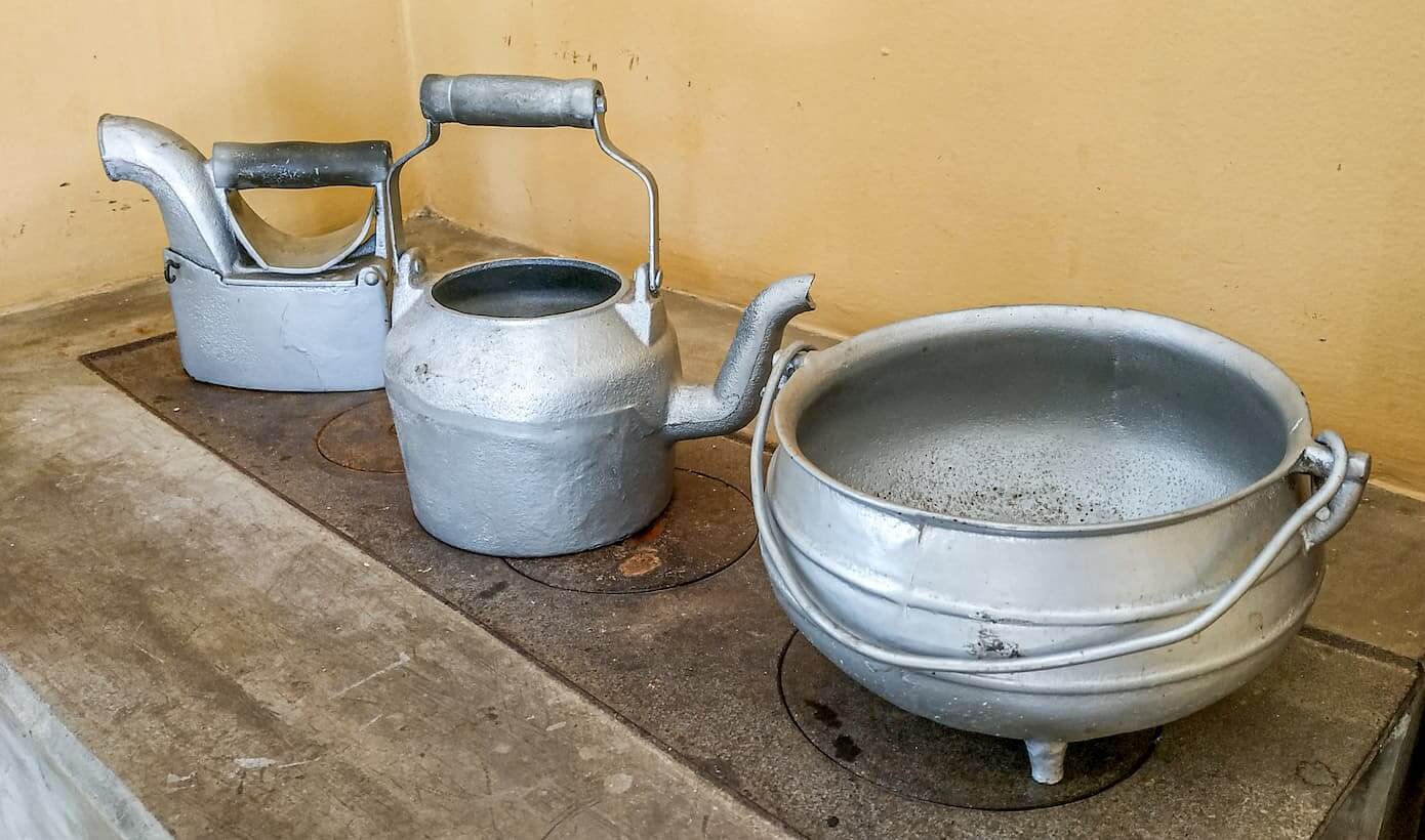 A imagem mostra um ferro à brasa, uma chaleira e um pequeno caldeirão que foram doados pelas irmãs Volpato à Casa de Cultura Roberto Carlos em Cachoeiro de Itapemirim.